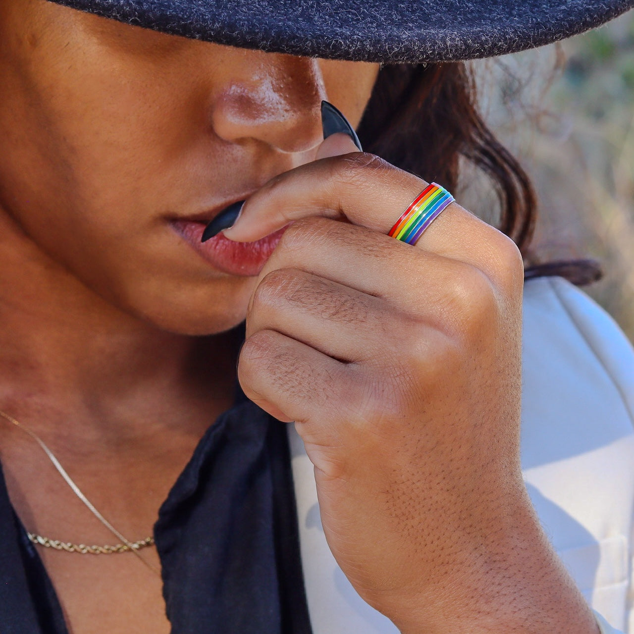 girl in hat wearing rainbow pride ring