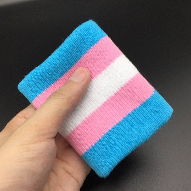 Hand holding a pink, blue, white, striped wrist band