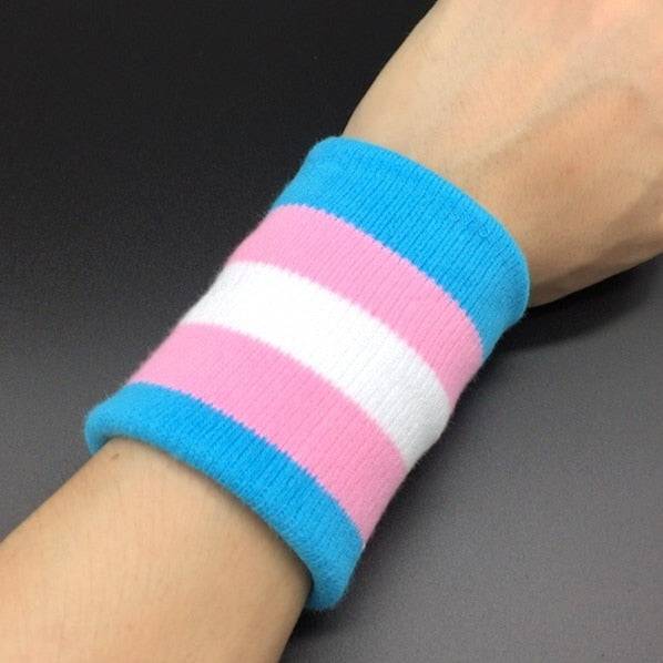 Persons wrist wearing a trans pride sweat band